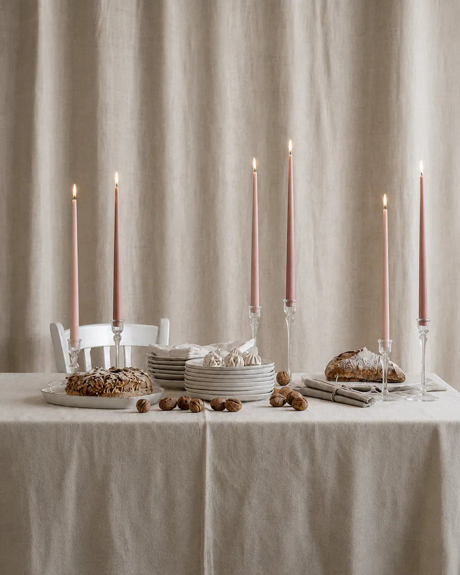 Mesa de evento con velas rosadas, candelabros y vajilla editorial