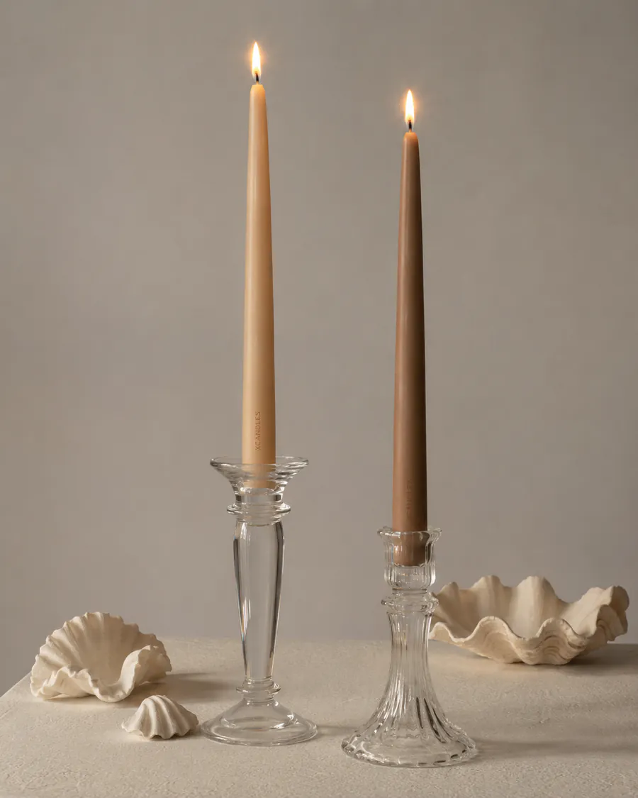 Velas cónicas con candelabros de cristal y conchas decorativas