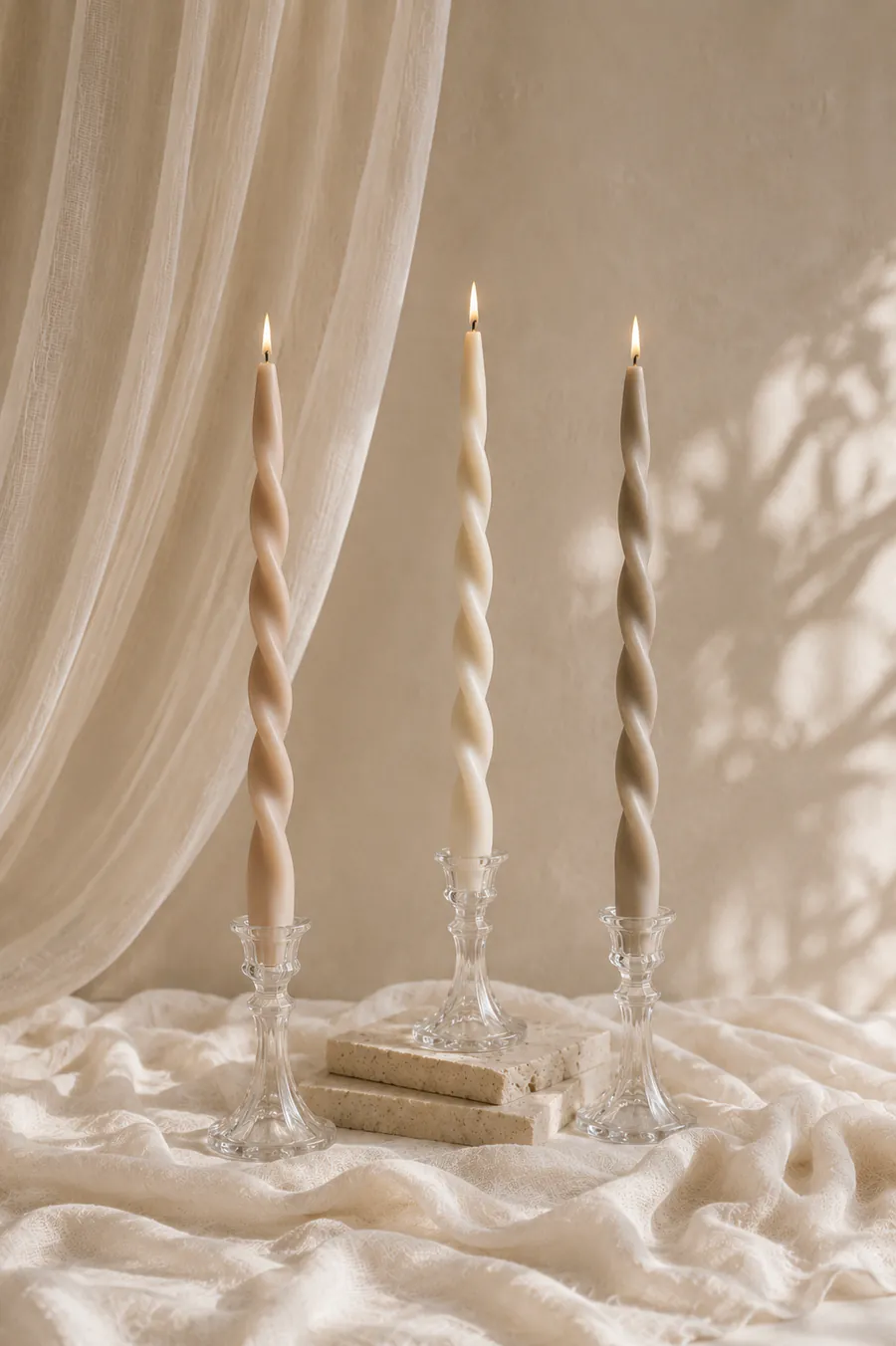Velas espiral nude con candelabros de cristal en composición editorial