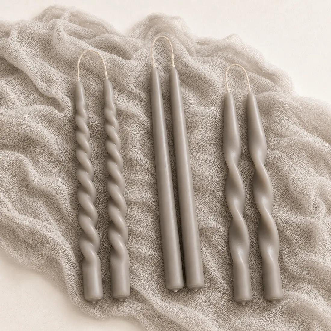 Velas espiral y lisas en tonos neutros sobre textil editorial
